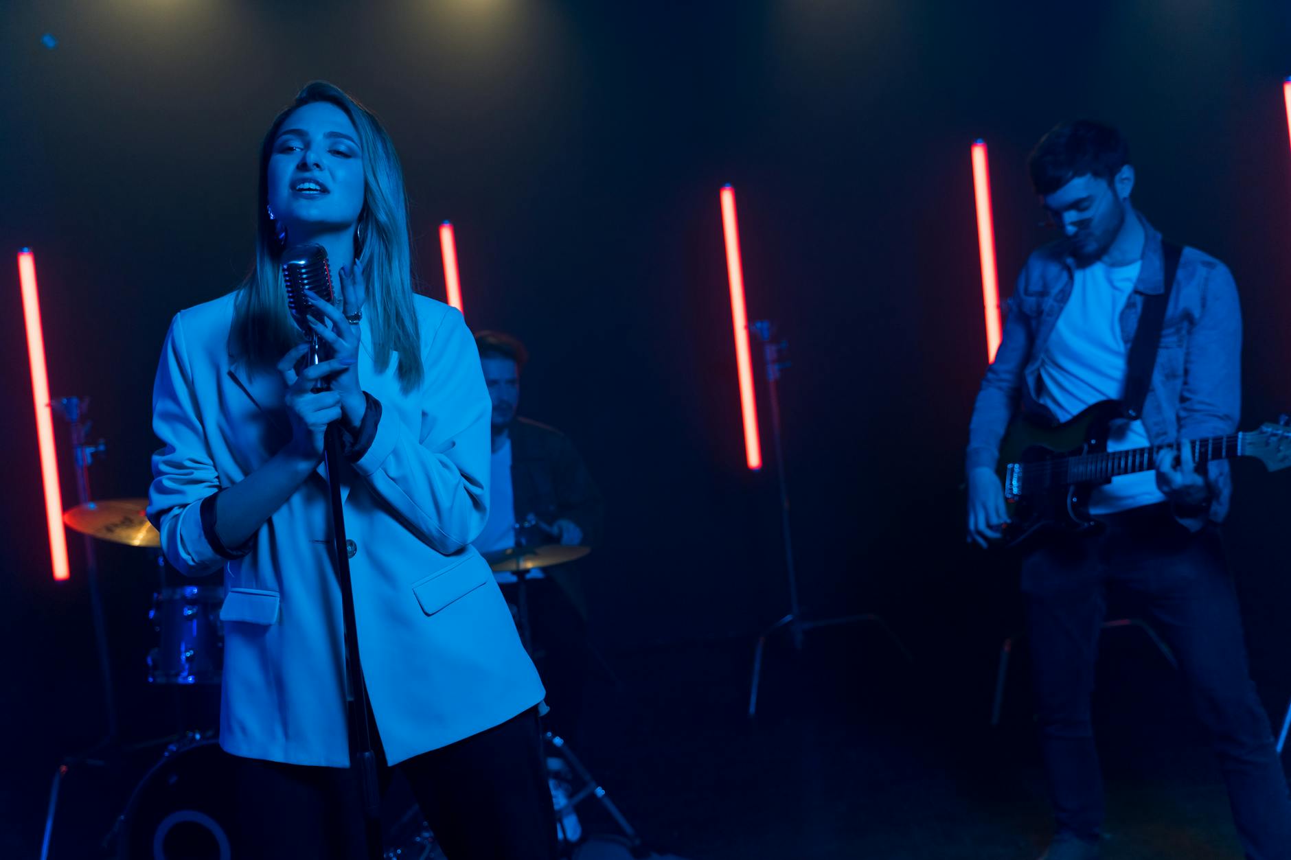 Energetic indie band performing on stage with vibrant neon lighting.