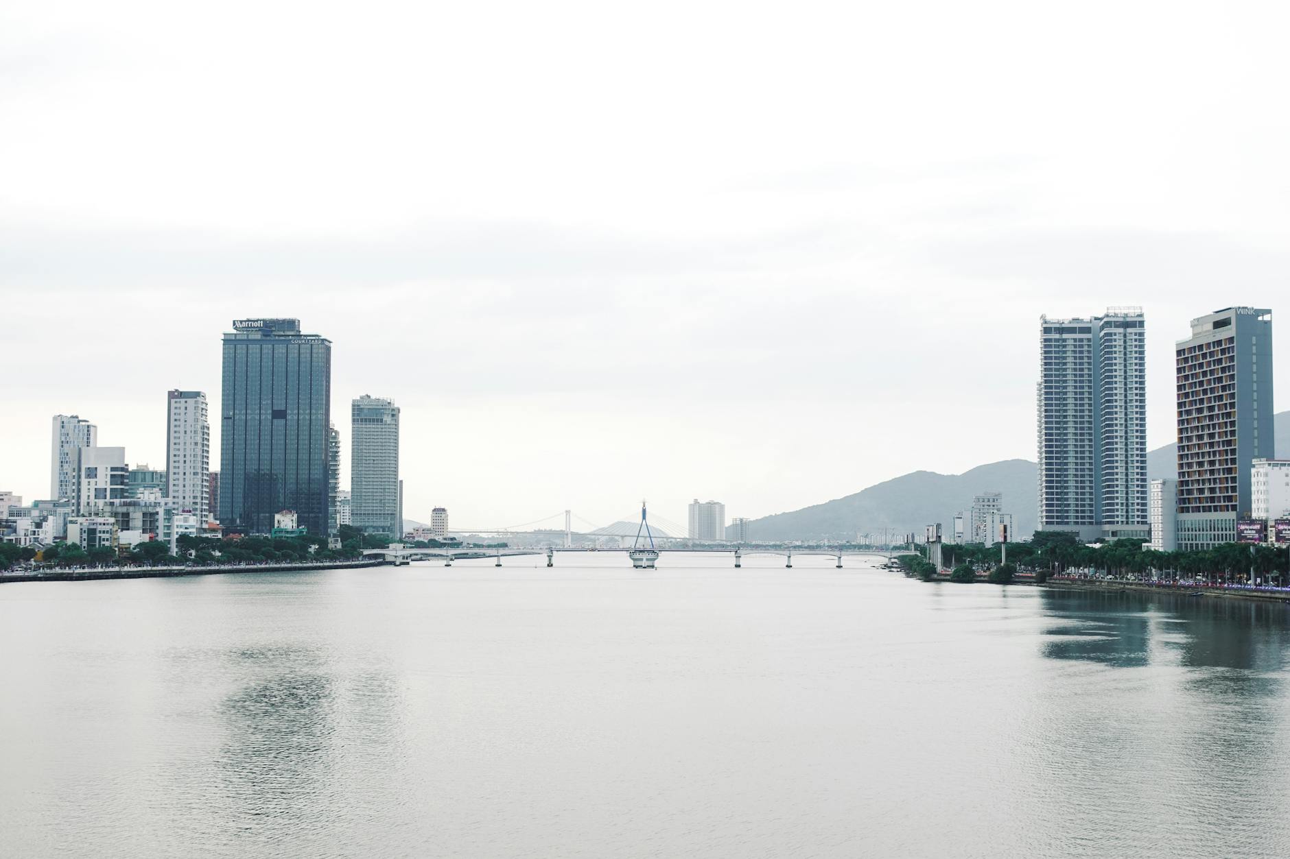 Beautiful view of Da Nang cityscape and Han River under cloudy skies. Ideal for travel and architecture visuals.
