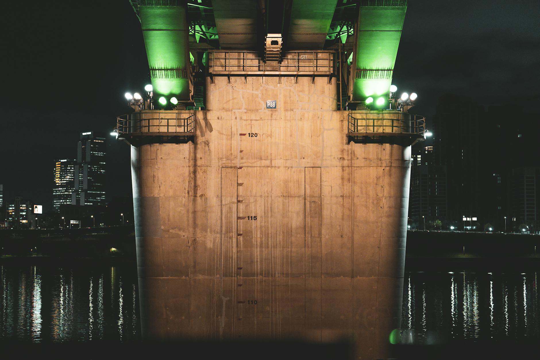 A night view of a brightly lit bridge over the Han River in Seoul, showcasing modern architecture.