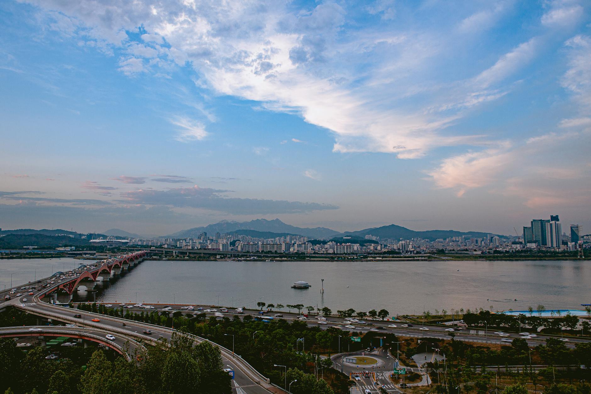 A captivating view of Seoul's skyline with the Han River and its iconic bridge under a beautiful sky.